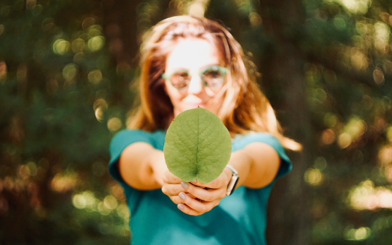 Woman in forest holding a leaf