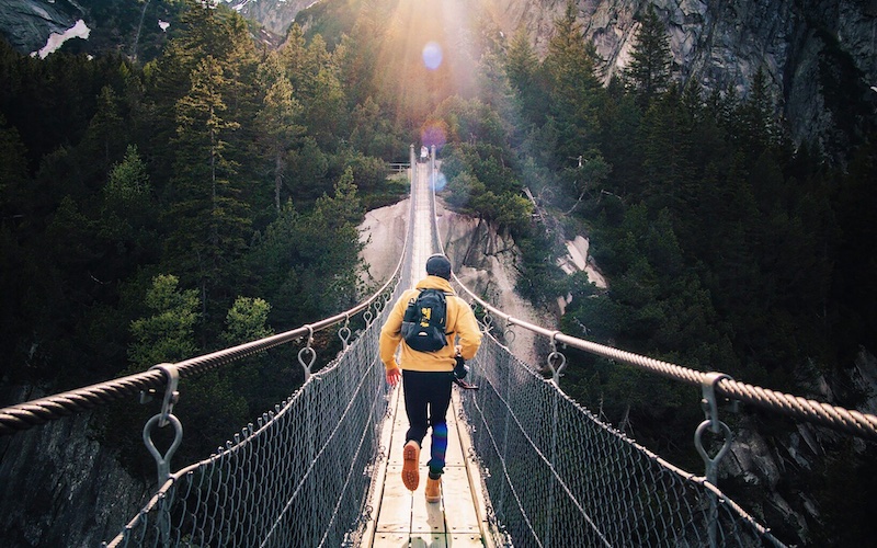 Man running over bridge at sunset